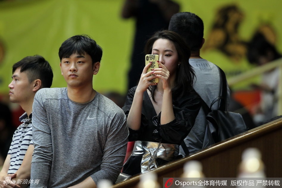 两位广厦女球迷在赛场边开心自拍，记录下这关键的季后赛时刻，她们身后是热情涌动的球迷看台，笑容里充满了对主队胜利的自信。