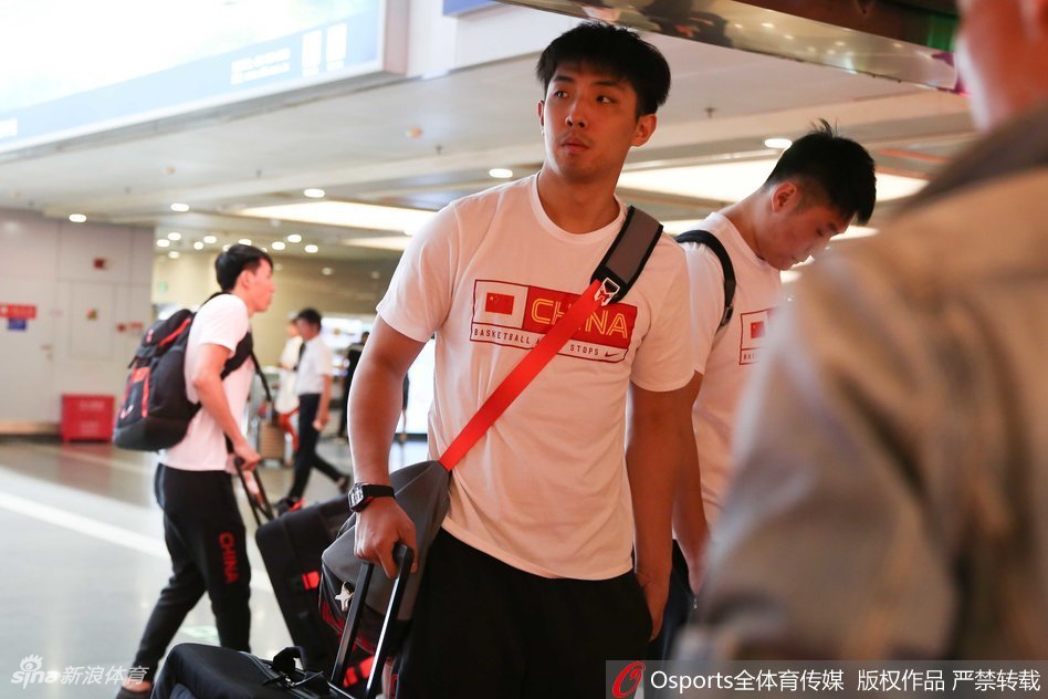 比赛结束后，获胜的中国男篮队员们围成一圈，将手紧紧搭在一起，年轻的脸庞上挂着汗珠，眼中闪烁着因胜利而生的光芒，团队精神在此刻闪耀。