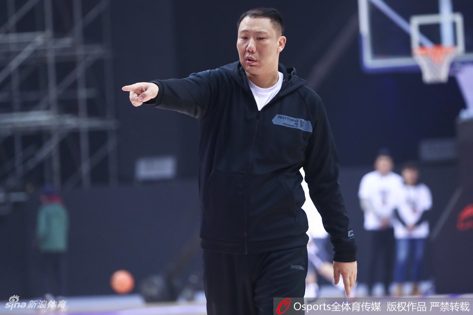 几名球员围成一个紧密的圆圈，中间一位队友正在进行拉伸。他们手臂搭在彼此肩上，仿佛古罗马战场上的战士同盟，肌肉的线条和专注的神情诉说着无声的信任与团结。