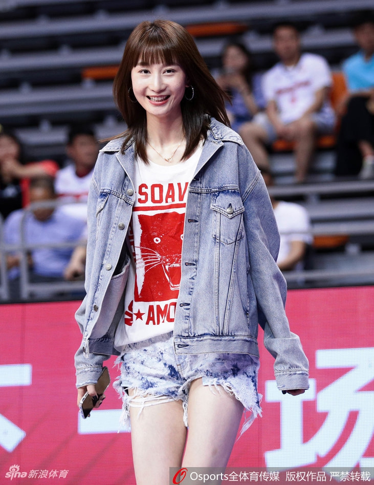 刘美长发随风轻扬，她身着简约便装坐在喧嚣的看台上，目光穿越人群，眼中只有球场上的丈夫，眉宇间既有紧张也透着坚定的信任。