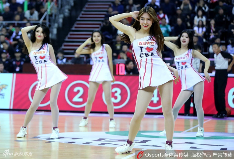 两位领舞队员动作舒展，身姿挺拔，在聚光灯下展现出极致的专业与自信，身后的队友们则组成完美的三角形阵型。