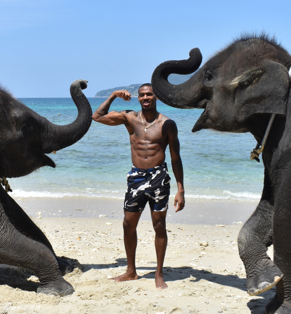 亚当斯身着深色休闲外套,在度假地点悠闲漫步,脸上带着惬意的微笑,眼神中透露出对眼前景色的欣赏,与赛场上的严肃形象形成鲜明反差。