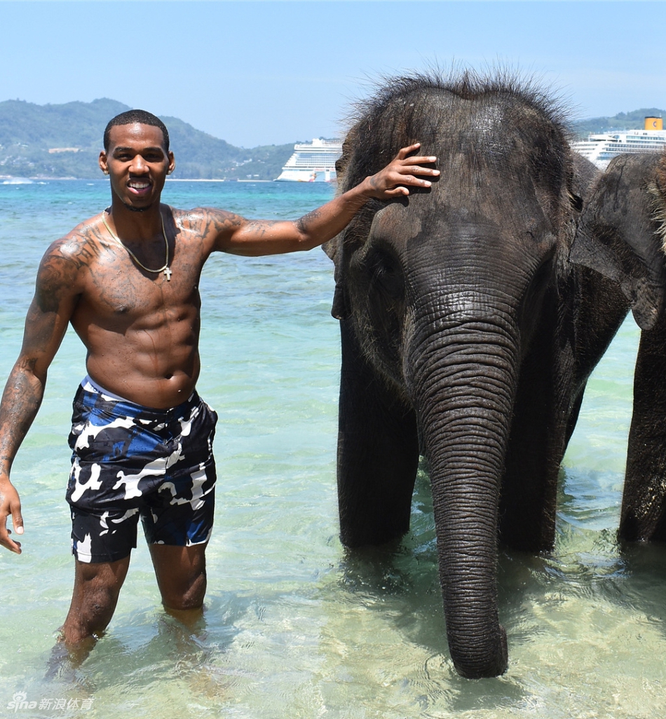 亚当斯站在一片开阔的水域旁,双手插兜,眺望远方。波光粼粼的水面映衬着他挺拔的背影,画面中充满了宁静与思考的意味。