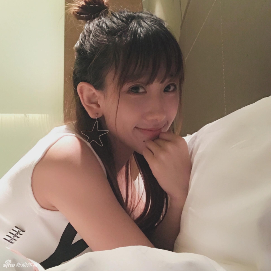 在聚光灯下,小娜自信地展示着啦啦队道具,身后的光影衬托出她优雅的身姿和迷人的气质