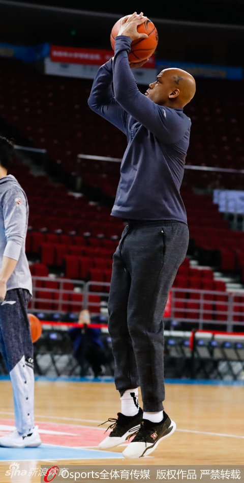 马布里双手持球置于腰间，眼神如炬望向远方，背景虚化的看台座椅仿佛静默的观众，等待着夜晚的喧嚣只为一人响起。