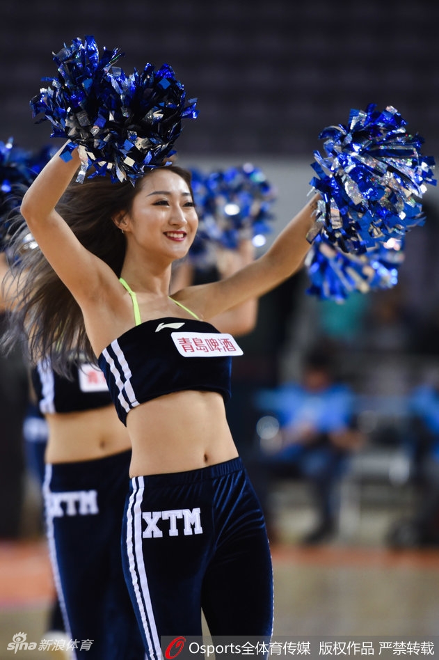 镜头拉近，这位扎着高马尾的啦啦队员正在聚光灯下专注表演，她的五官精致立体，身着的金色流苏上衣随着动感的音乐节奏摆动，回眸一瞥间，既有女团的飒爽，又不失东方女性的柔美。