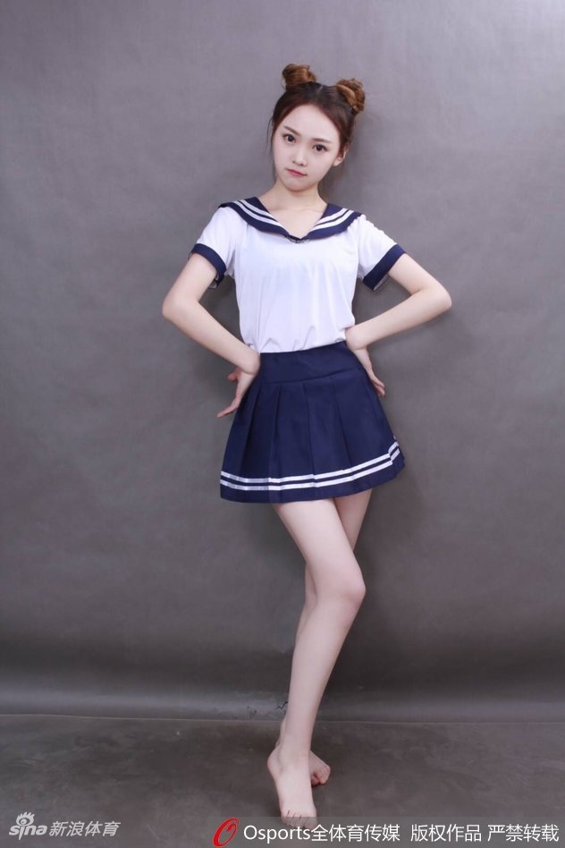 女孩身穿校园风毛衣背心，在训练场馆中压腿热身，展现出舞蹈生的柔韧与专注