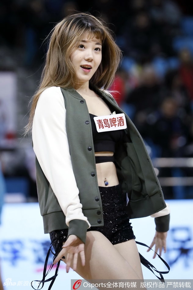 队员高速旋转时秀发与裙摆齐飞，自信微笑直面镜头，定格动感瞬间