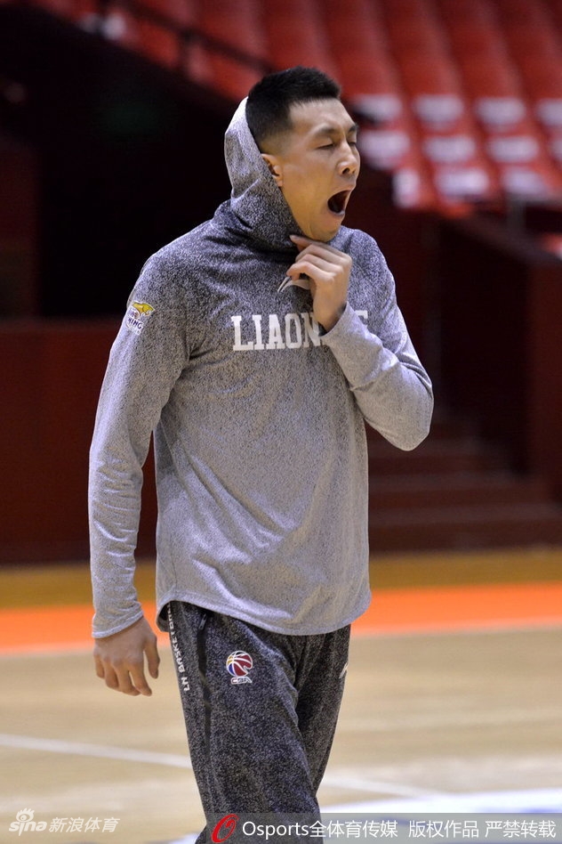 郭艾伦单手控球,眼神坚毅地望向远方,仿佛在思考当晚比赛的战术,身后的训练背景虚化,更凸显了他的专注力。