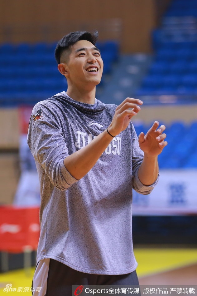 易立正在助理教练的协助下进行拉伸,这位老将的表情专注而坚定,他是队中唯一经历过上一次双杀广东的老队员。