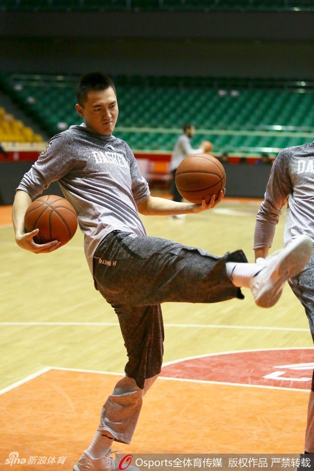 夕阳透过球馆窗户洒在罚球线上,球员在安静中反复练习投篮动作