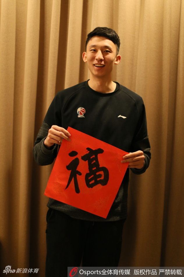 镜头定格在喜气洋洋的一刻，八一男篮的将士们身着鲜红训练服，在农历新年前夕齐聚一堂。雷蒙手持春联居于中央，众人脸上洋溢着灿烂的笑容，那是一种褪去赛场凌厉后，如兄长般的亲切与温暖，仿佛正隔着屏幕向每一位支持者作揖拜年。