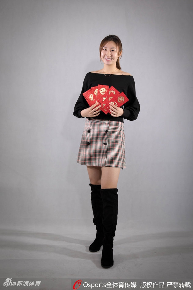 李月汝在人群中显得格外突出，她弯下腰以便能和前排队友一同入镜，这个贴心的动作细节展现了她憨厚可爱的性格，她手中的福字仿佛也承载着对球迷沉甸甸的祝福。