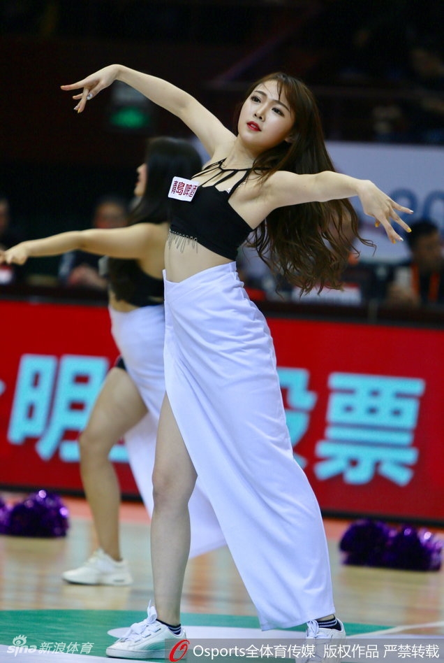 女孩扎着双马尾，身穿格子短裙搭配白色长袜，在篮球架下摆出俏皮可爱的姿势