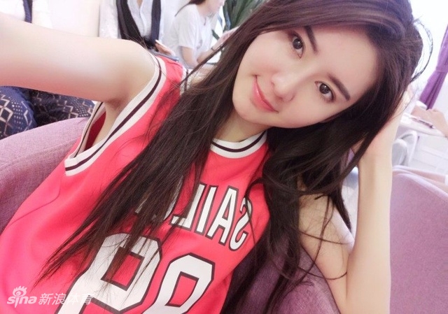 萌萌在篮球场上优雅站立,修长身材与篮网构成一幅动感画面,笑容比阳光还灿烂