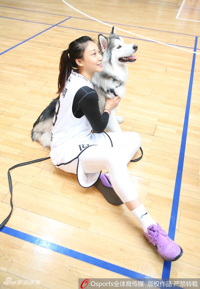 高颂单手托起懵懂小狗,眼神里满是好奇与宠溺,如同她在篮下精准地托起篮球,轻松写意。