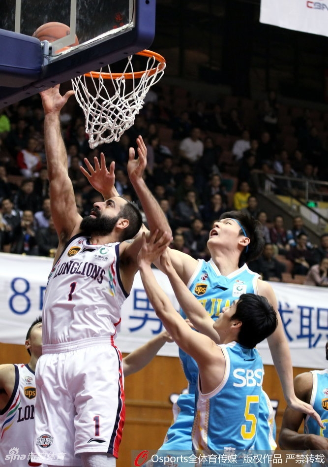 广州队球员克里斯顿在福建队球员的严密防守下强行突破，眼神中透露出必胜的决心。