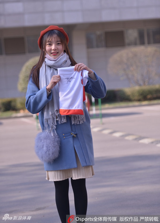 戴着可爱发饰的女球迷手托香腮,眼神灵动,似乎正在盘算着主队下一次进攻的走向,俏皮又专注。