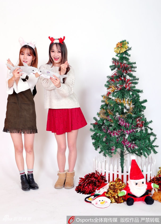 姑娘双手托腮,露出乖巧可爱的表情,红色蝴蝶结发饰与身上的圣诞裙装相得益彰