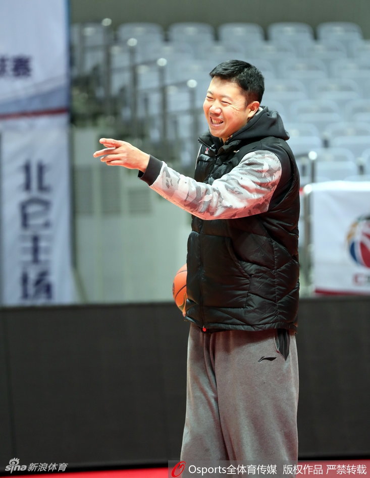 训练间隙，大郅双手叉腰站在场边，若有所思地观察着场上的局势。他身上那件简单的训练服，似乎还留存着当年驰骋赛场时的汗迹与荣光。