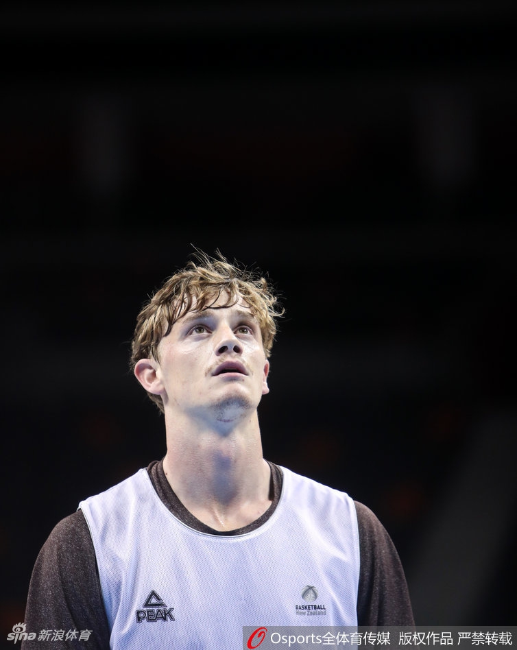 训练结束后,球员们在场边进行拉伸放松,助理教练正在帮助一名队员进行肌肉放松,氛围轻松融洽。