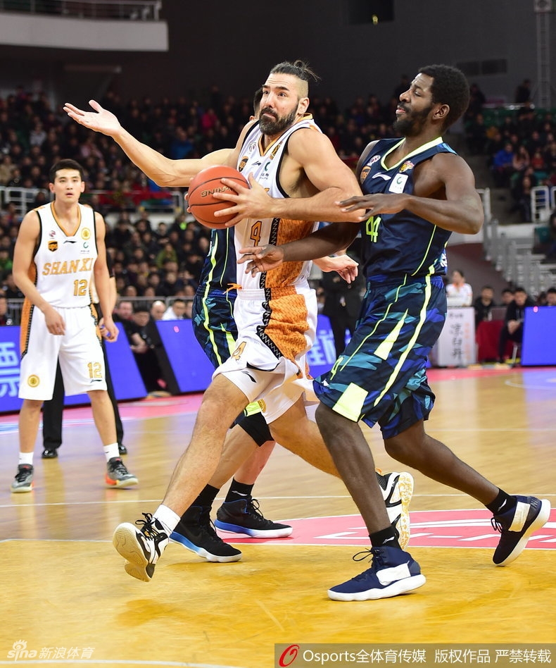 易建联在山西队三人合围之下高高跃起，一双长臂在空中划出满弓，指尖轻拨将篮板球稳稳揽入怀中，眼神中透露出不容侵犯的王者霸气。