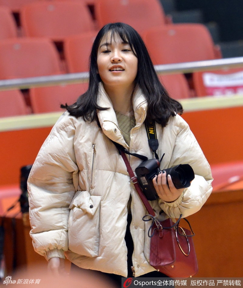 特写镜头中,美女记者正低头检查刚才录制的采访素材,夕阳的余晖透过训练馆的玻璃窗洒在她身上。她手中的录音笔和笔记本,见证了这一天高强度工作的累累硕果。