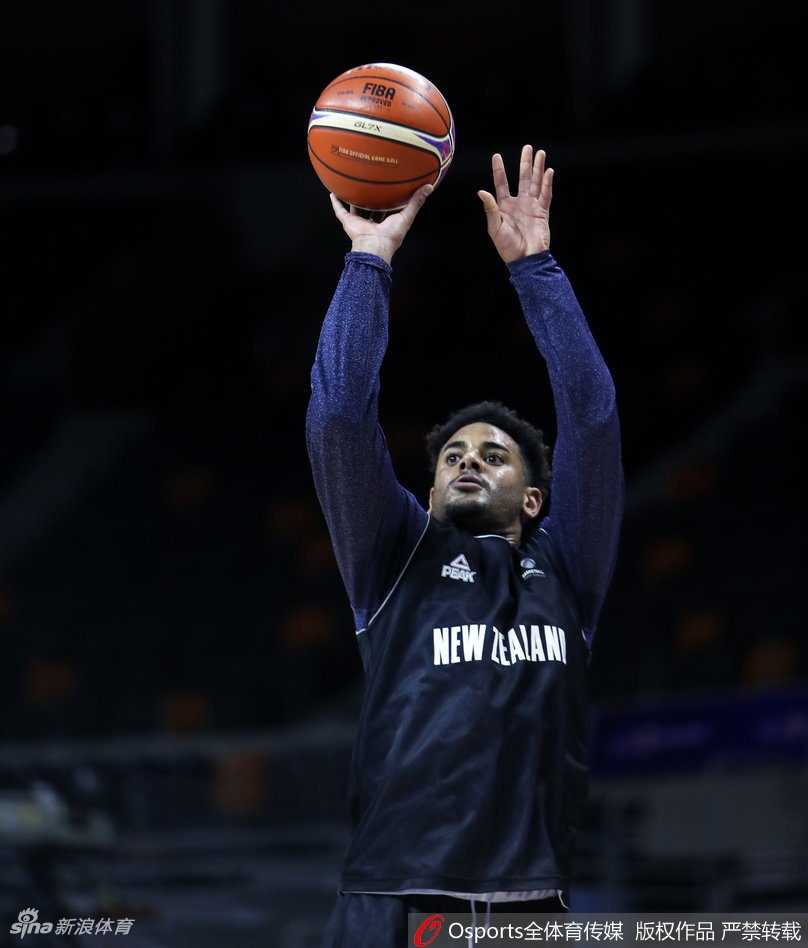 新西兰男篮队员在体能教练指导下进行核心力量训练,汗水浸湿球衣,神情专注而坚毅。