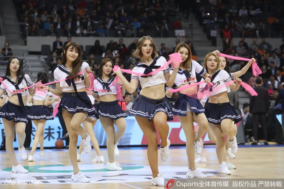 近景画面中，领舞的队员笑容甜美，手中舞动着彩色花球，学生服的深色领带与白色衬衫形成鲜明对比，将少女的活力与优雅平衡得恰到好处。