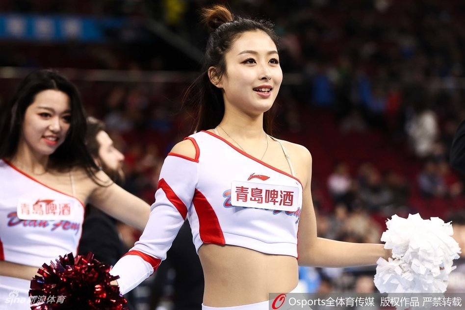 镜头拉近，这位篮球宝贝的笑容极具感染力，她头戴闪亮的银色发饰，伴随着强劲的鼓点有力地挥舞着手臂，那股自信与张扬瞬间点燃了全场的热情。