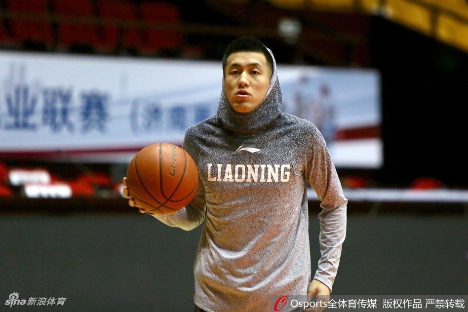 辽宁男篮全队在场上进行拉伸训练,郭艾伦和韩德君位于队伍中间,两人动作同步,画面和谐,展现了球队良好的团队氛围。