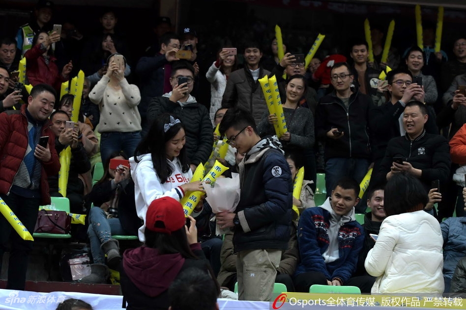 幸福的女孩踮起脚尖,为单膝跪地的男友送上深情的吻。周围的球迷纷纷举起手机,记录下这篮球与爱情完美交织的经典瞬间,整个体育馆都沉浸在幸福的海洋中。