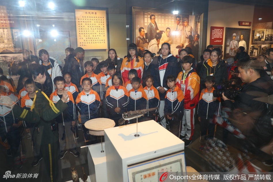 孩子们仰着稚嫩的脸庞，目光炯炯有神地望向展柜，女篮队员们则像守护者一样陪伴在侧。