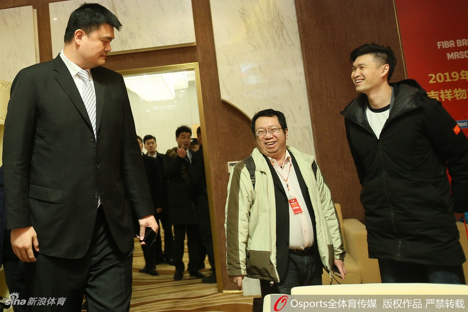 仪式现场的姚明目光炯炯，神情专注地审视着舞台上的动态，高大身影在聚光灯下显得格外引人注目，仿佛一座移动的长城守护着中国篮球的荣誉。