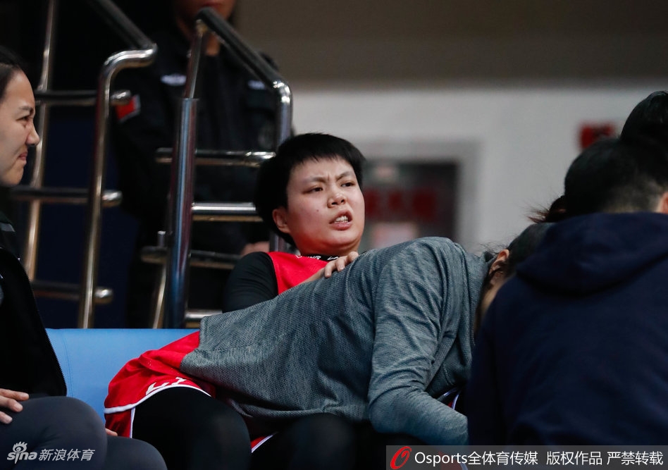 北京队主教练张云松在暂停期间，手持战术板蹲在地上，神情严肃地向队员们面授机宜，队员们围成一圈认真聆听。