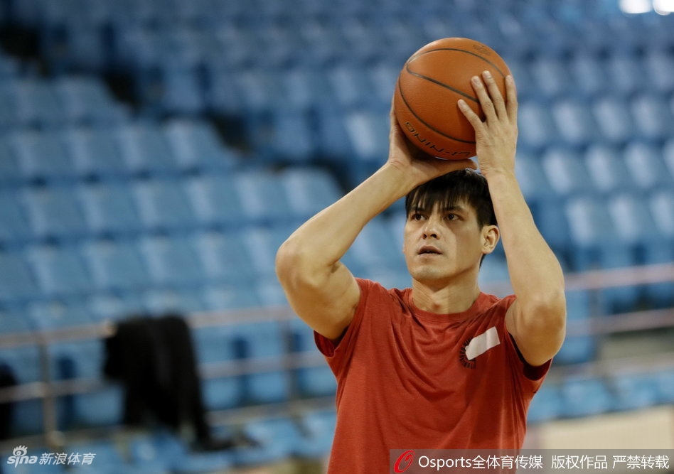 主教练张庆鹏手持战术板，神情专注地向球员们讲解跑位细节，手势坚定有力，传递着他的战术理念与临场指挥智慧。