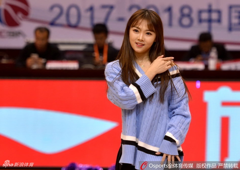 一位眼神专注的啦啦队员在场边候场，妆容精致，静待上场指令