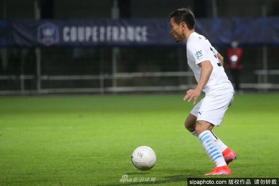 长友佑都身披FC东京战袍在赛场上全神贯注地防守，眼神中透露出坚毅与经验