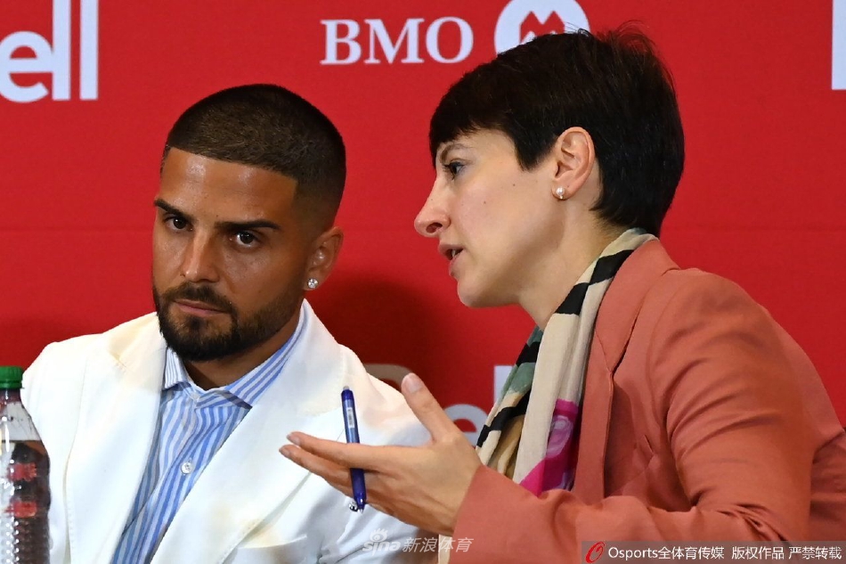 因西涅与俱乐部高层并肩站立，共同展开印有球队标志的红色围巾