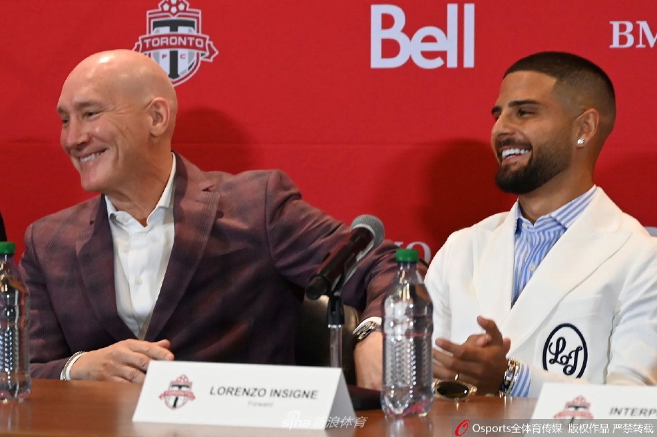 因西涅在新闻发布会聚光灯下认真倾听提问，眼神专注而坚定