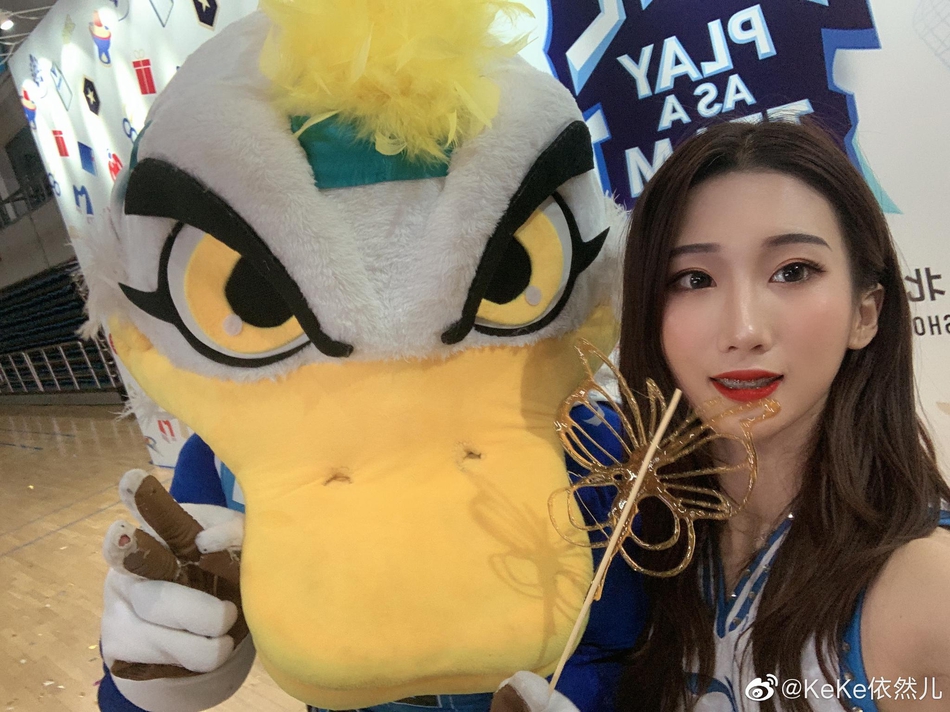 结束了一下午的排练，队员们围坐在地板上休息交流。夕阳透过窗户洒在她们身上，每个人的脸上都洋溢着笑容，空气中弥漫着团队之间轻松而温暖的氛围。