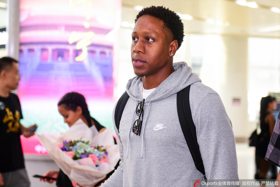 以赛亚·卡南手捧鲜花现身济南机场，他面带微笑望向镜头，身旁的女友长发披肩，两人神情轻松，为即将开启的CBA征程留下第一抹亮色。