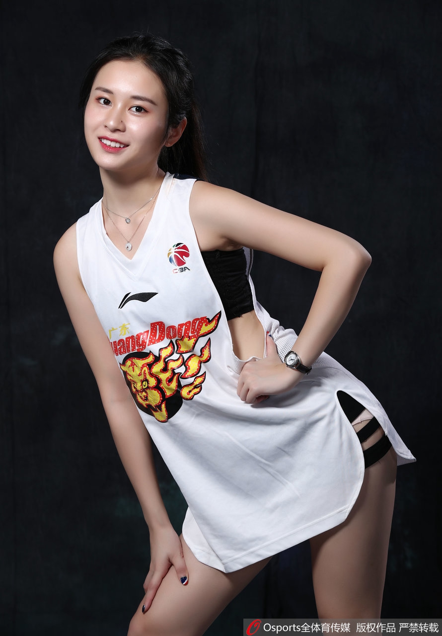 一位扎着利落高马尾的啦啦队员在镜头前展示完美的柔韧性，她轻松地完成了一字马，笔直修长的双腿在深色地板的映衬下更显白皙，专注的眼神和挺拔的上半身，将力与美演绎得淋漓尽致。