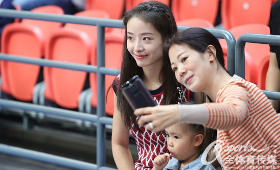 一家三口在北控队徽前留下珍贵的合影，孙桐林高大的身躯护住妻女，妻子抱着女儿面对镜头露出甜蜜的微笑，画面充满爱意与温情。