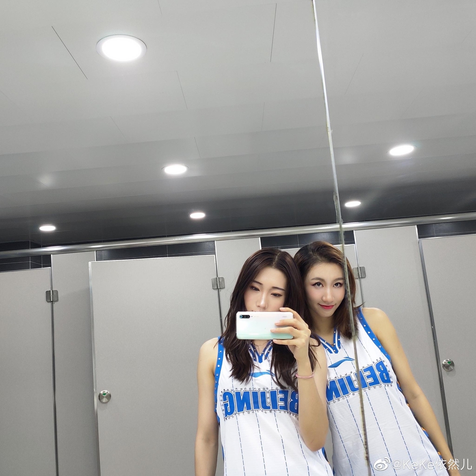 镜头拉近，一位队员正在镜子前单独练习表情管理。她的眼神明亮而坚定，嘴角上扬露出标准的八颗牙微笑，即使在静态的照片中，也能感受到她传递出的热情与亲和力。