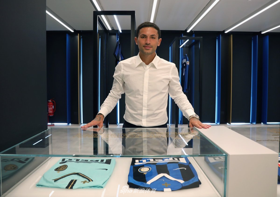 森西在办公桌前落座，双手交叠姿态放松，专注倾听工作人员介绍俱乐部历史