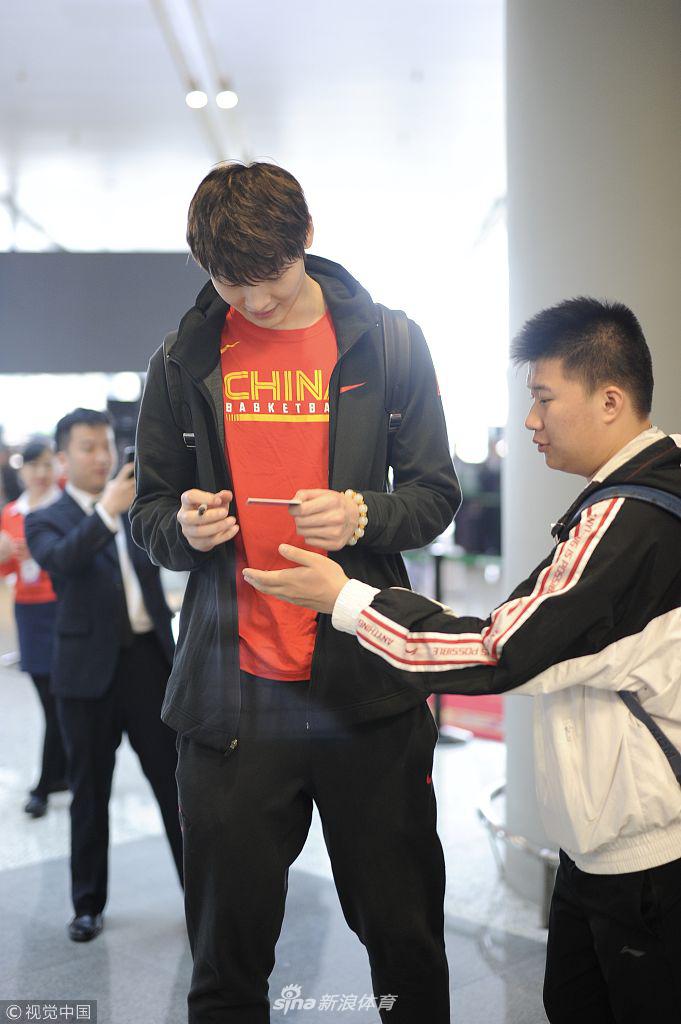 内线支柱王哲林身穿休闲服，背着双肩包，面对镜头露出憨厚而自信的笑容，他已经准备好在内线为球队提供强有力的支持。