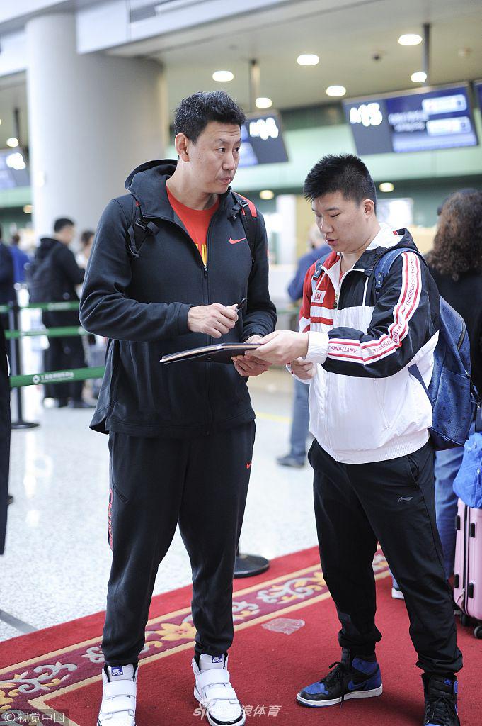 主教练李楠被热情的球迷团团围住，他低头弯腰，神情专注而认真地为球迷手中的篮球签名，举手投足间尽显亲和力与大将风度。