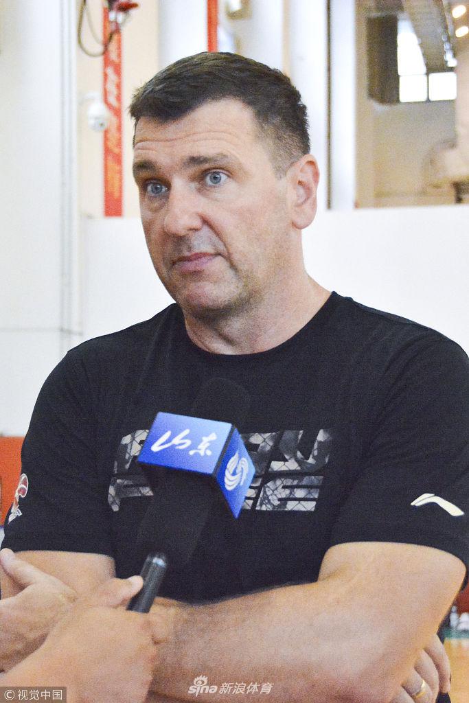 贾诚双臂肌肉充血隆起，在教练的注视下稳稳推举着手中的器械，眼神坚毅如铁，仿佛要将半决赛失利的遗憾全部转化为向上的力量。