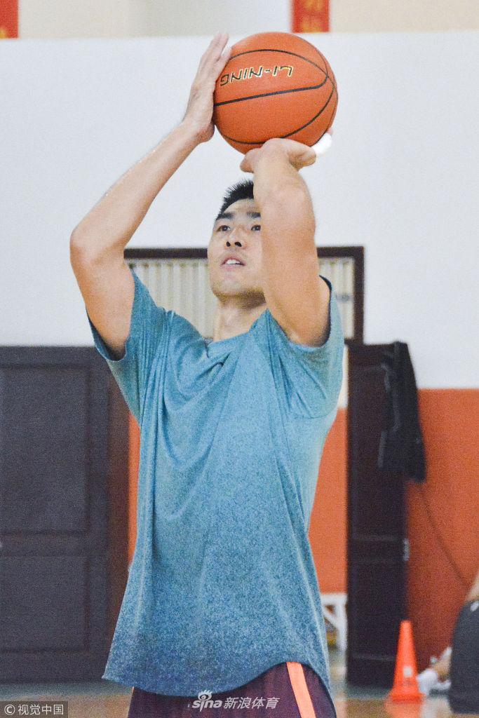 助教托米正在为一名年轻球员辅助拉伸，球员表情略显痛苦却又充满信任，这不仅是身体的放松，更是球队凝聚力在细微处的体现。